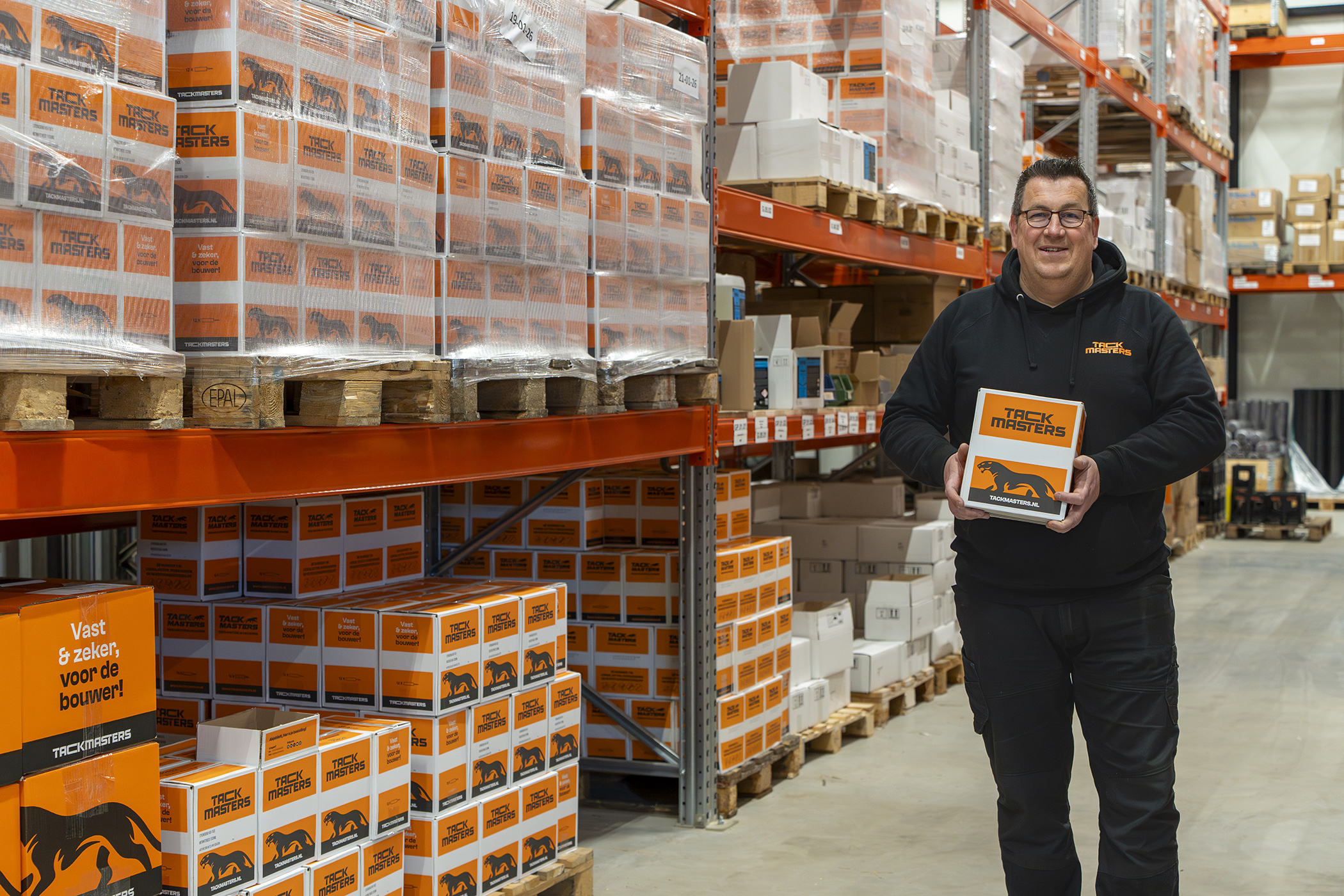 Bas in het magazijn met een Tackmasters doos.